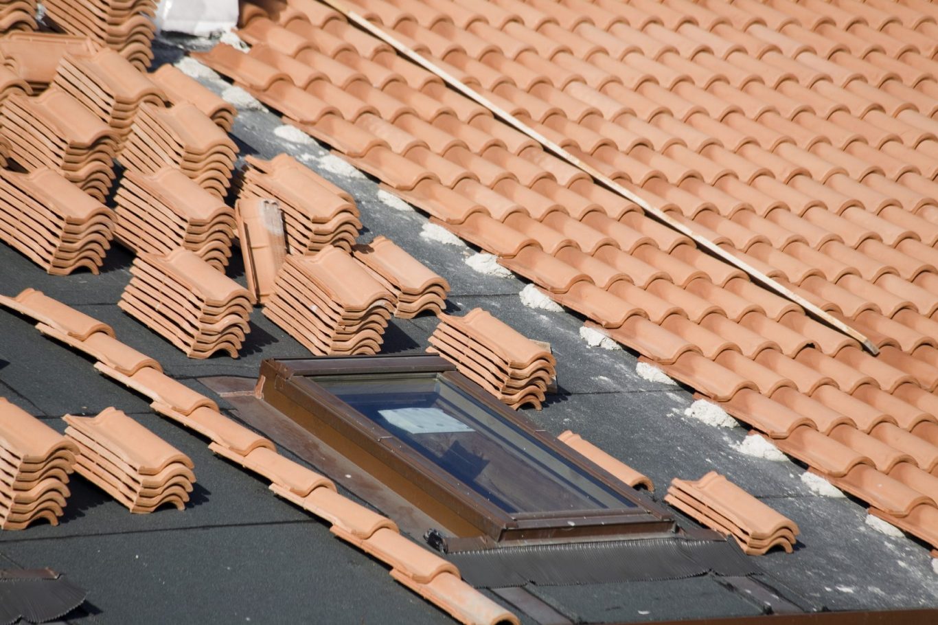 A rooftop with terracotta tiles and a skylight.