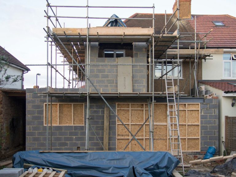 Construction site featuring a building with scaffolding and wooden framework.