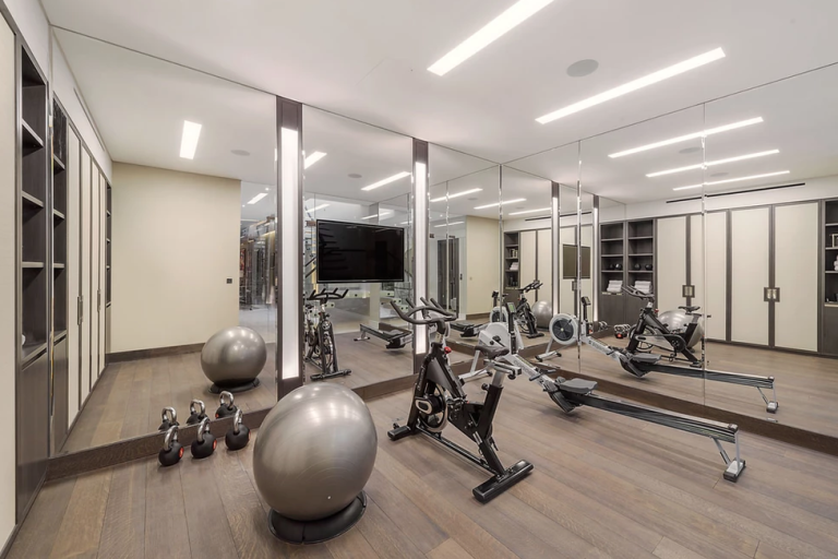A modern home gym featuring exercise equipment and large mirrors.