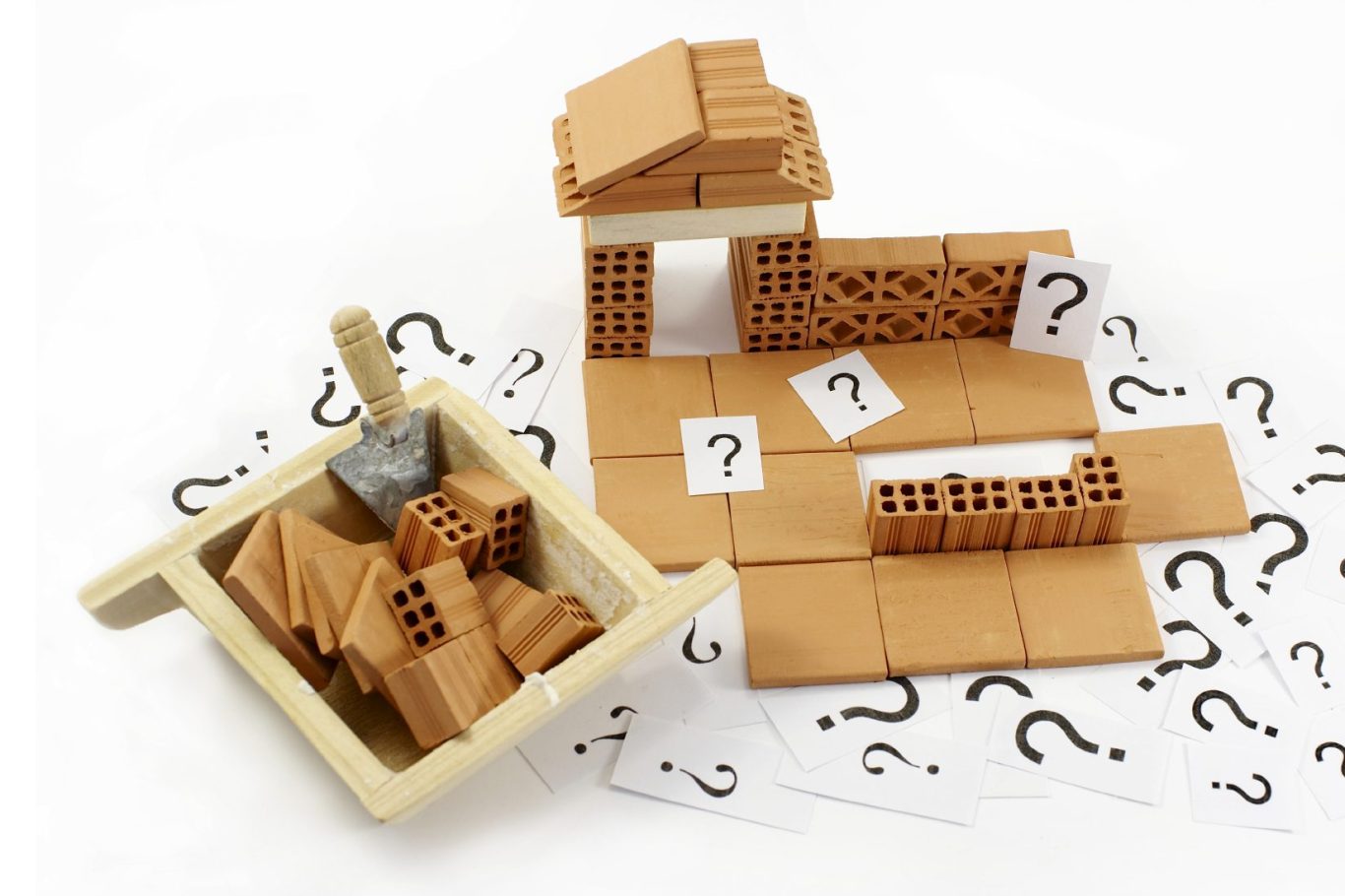 A wooden cart with bricks and question mark cards, suggesting construction or planning.